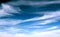 Cirrus high clouds in blue skies float above the earth