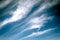 Cirrus high clouds in blue skies float above the earth
