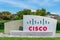 Cisco sign near Cisco headquarters campus in Silicon Valley. The red and blue logo depicts the two towers of the Golden Gate