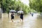 Citizen crossing through puddles with umbrella