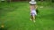 Citizen girl in dress walking through grass in rural house yard