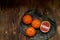 Citrus on a beautiful clay plate. Juicy raw fruits, vitamins on a simple wooden background.Village style. View from