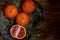 Citrus on a beautiful clay plate. Juicy raw fruits, vitamins on a simple wooden background. Village style.View from