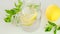 Citrus cocktail with mint leaves. Mineral water pours into a glass. Sassy lemon water. Lemon mint water with ice in a