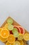 Citrus composition on chopping board. Many halved lemons, limes, grapefruits. Vertical, copy space