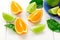 Citrus fruits with green leaves. Orange, lime segments on white wooden surface