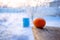 Citrus fruits, mandarin lie on a wooden table against the background of a winter village, frost