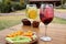 Citrus gin and tonic and red fruits with vegetable snack on wooden table outdoors, toast to celebrate love