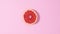 Citrus grapefruit rotating on  pastel pink background. Stop motion