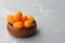 Citrus kumquat fruits in wooden bowl. Healthy vegan food. Side view, copy space.