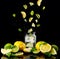 Citrus lemonade with lemon, lime and ice in a glass on a black background. Splash. Levitation.