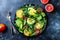 Citrus salad with mixed greens and blood orange on black ceramic plate. Vegan, vegetarian, clean eating, dieting