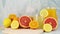 Citrus summer decoration with sliced grapefruit, lemons, oranges, lemonade in drinking glass and orange juice in jug