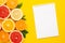 Citruses fruits and notebook on yellow background with copyspace, fruit flatlay, summer minimal compositon with grapefruit, lemon