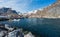 The city of Aa in Lofoten, Norway. Rorbuer and harbor underneath steep snow covered mountain peaks and blue sky.