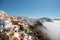 City above the clouds. Views of Oia village, Santorini island, Greece.