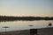 City beach at sunset. An island and a passing ship can be seen in the distance.