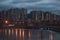 City buildings at dusk behind frozen river