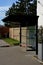 city bus stop. glass shelter with integrated wooden bench.