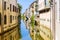 The city canal San Massimo runs among residential houses in the