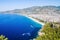 City on the coast between the mountains and blue sea with a sandy beach. View on the Kleopatra Beach, Alanya, Turkey.