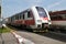 City diesel train at crossing with barriers