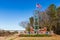 City of Flowood welcome sign with American Flag waving in the wind, and some holiday