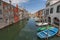 City landscape with canal, boats and colorful reflections on the water in the picturesque old town in Chioggia, Venice, Italy