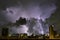 City landscape lightning storm behind clouds at night