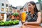 City lifestyle people. Young urban Asian woman drinking a beer pint at outdoor pub on outside terrace in summer