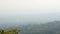 City lying at foot of mountain in thick haze, peaceful landscape, panorama view