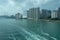 City near the sea. Waves on the water from the boat sailed away, a large bridge in the distance.