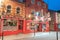 City at night under street and lights from buildings with bright red traditional fronts and signage