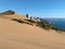 City and ocean behind sand dunes