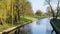 City park on sunny spring summer weather. Park with river reflections, trees and green grass. Landscaping Place for