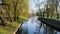 City park on sunny spring summer weather. Park with river reflections, trees and green grass. Landscaping Place for