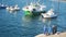 City pier with fishing boats, three men stand on the shore