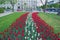 City Riga, Latvia Republic. Latvian flag from tulips, red and white. Tourists walk on street and cars drive. May 7. 2019 Travel