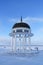 City rotunda on shore of frozen snowy lake in winter on a sunny frosty day