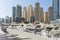 City scape with modern high-rise buildings, man made river with yachts and blue sky in background at Dubai