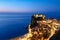 The city of Scilla Calabria Italy. Elevated view of the illuminated Ruffo castle at sunset
