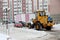 City services snow removal special equipment after snowfall. urban utilities. Tractor loads snow into the truck
