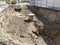 City sewer, repair and replacement of faulty pipes. Large trench with sewer wells