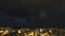 City skyline at night timelapse. Fast moving sky clouds and storm lightning in full moon