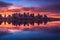 city skyline reflecting onto calm water at twilight