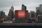 A city skyline with tall buildings and a red billboard. Generative AI image.