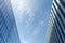 City skyscrapers bottom view against blue sky. Low wide angle shot, from ground. Glass facade Architecture exterior.