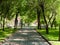 City square. Cobblestone path, benches for rest. Green vegetation in the park