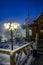 a city street covered with snow with brightly lit lampposts. A city street on a foggy winter night, illuminated by street lamps.