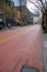 a city street has two lines of red asphalt next to a manhole